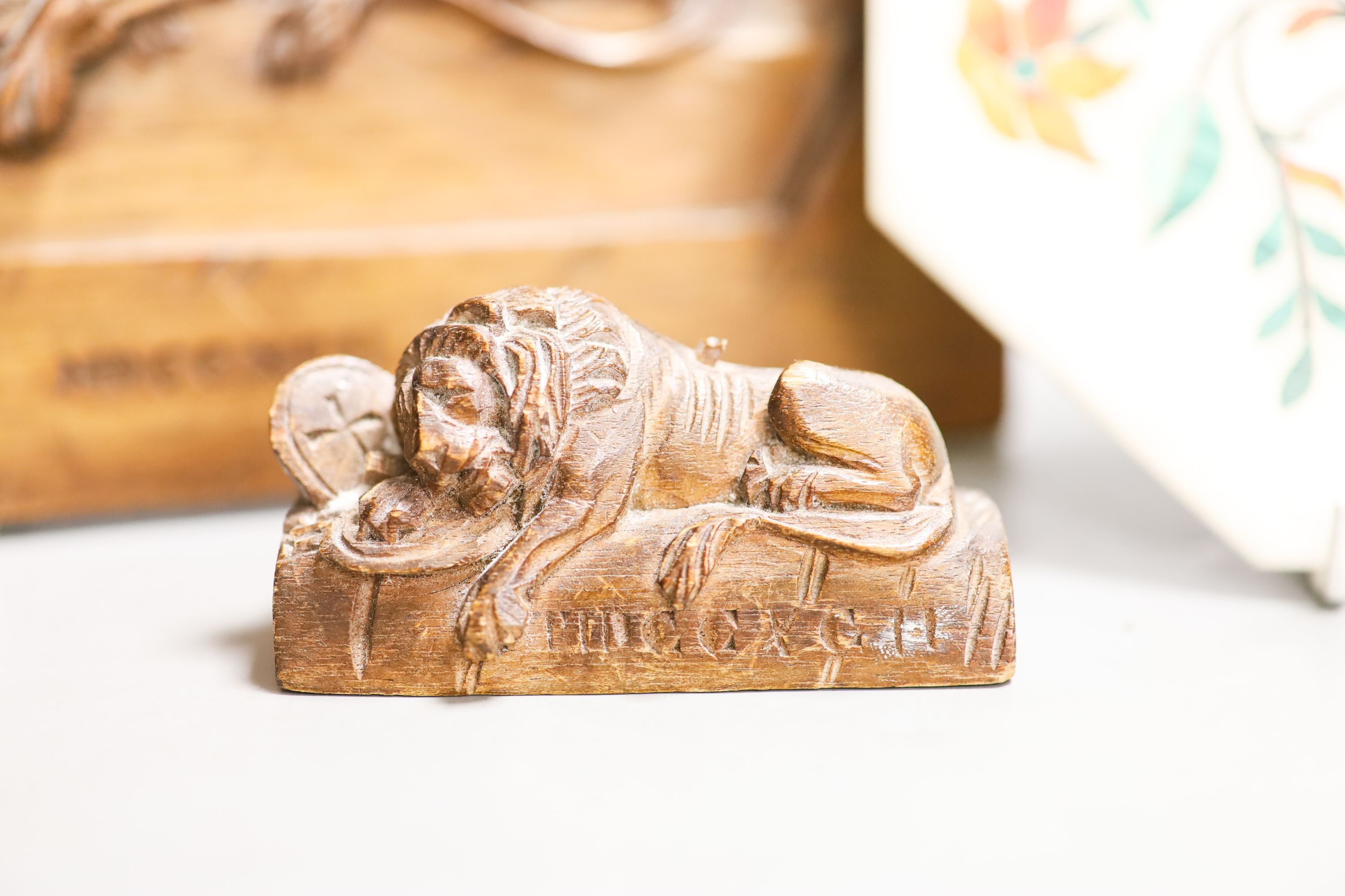 A walnut Lion of Lucerne plaque and carving and an Indian hardstone plaque